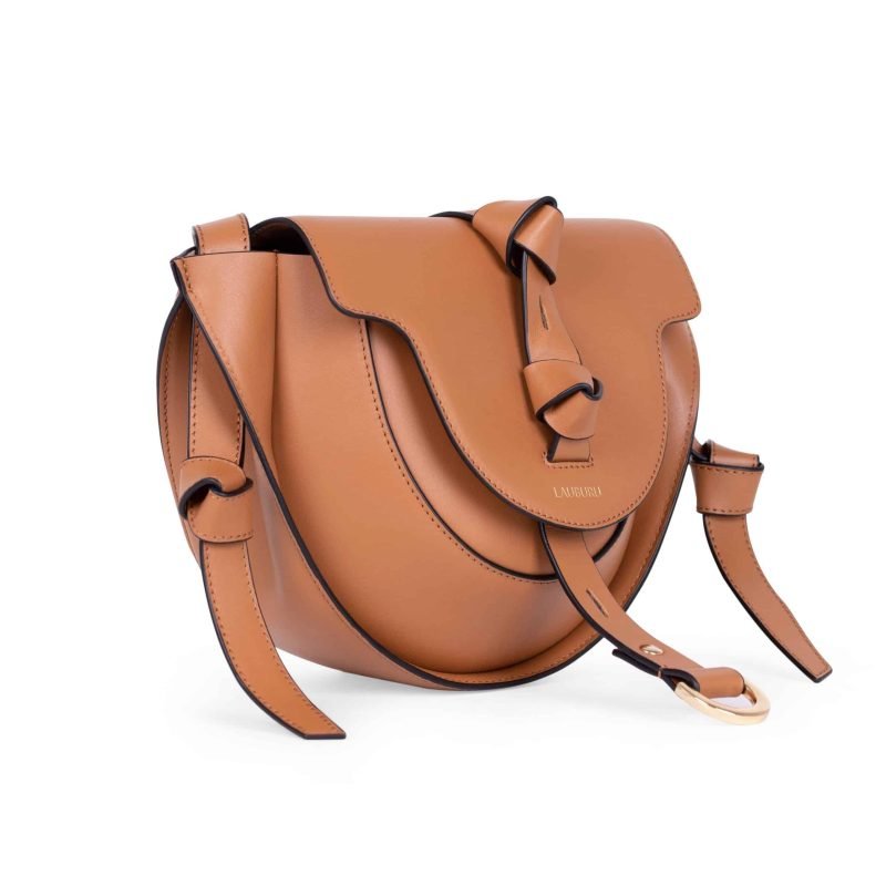 Bolso Lauburu en color camel con cierre de tira decorativa y diseño estructurado. Acabado elegante con detalles de nudos y hebilla dorada, ideal para looks sofisticados