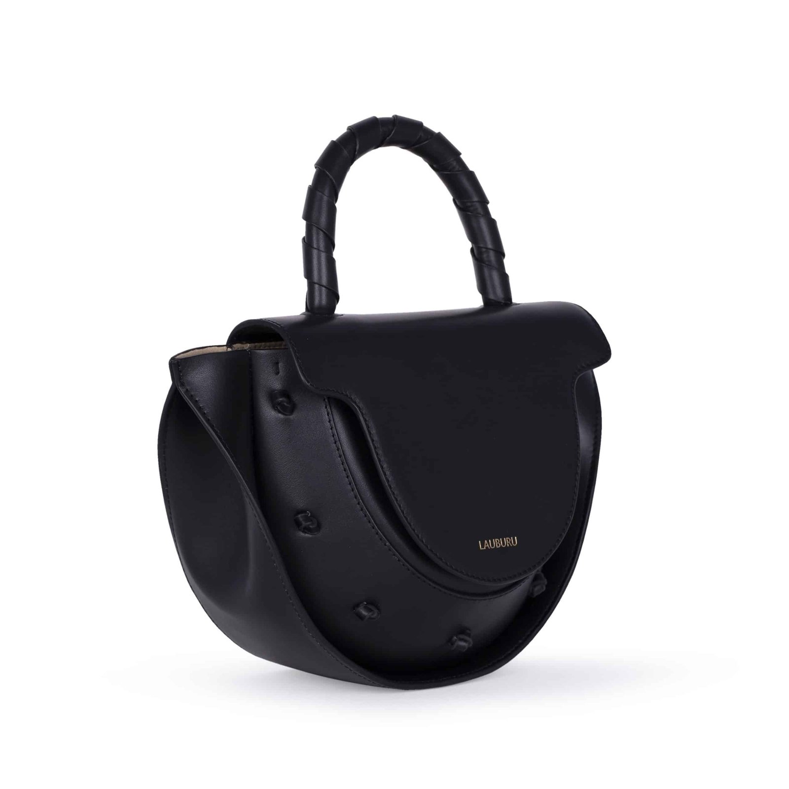 Bolso Lauburu de piel negra con asa trenzada y detalles de nudos en relieve. Diseño estructurado con solapa curva, bordes en contraste y logotipo dorado grabado. Complemento elegante y versátil para looks sofisticados