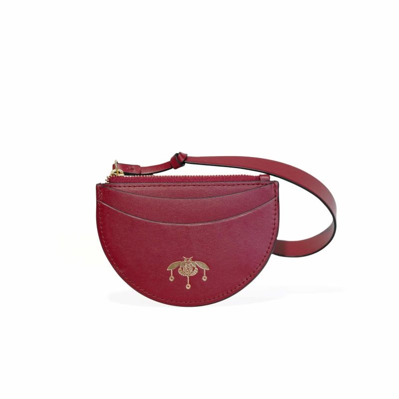 Tarjetero de piel burdeos Viviana de Lauburu con logo dorado grabado y correa ajustable. Diseño semicircular con costuras decorativas y cierre de cremallera dorado, ideal para un estilo sofisticado y práctico.